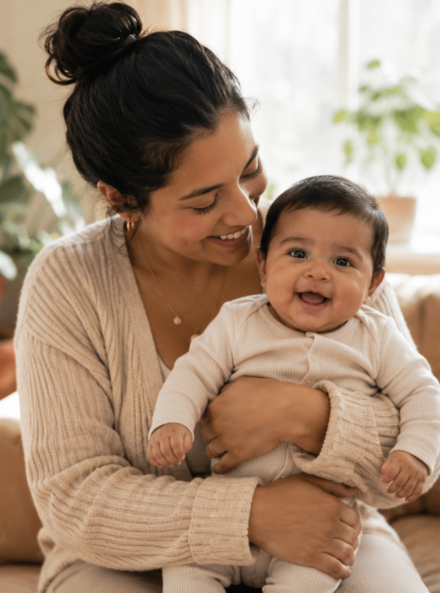 A mother smiling as she holds her baby